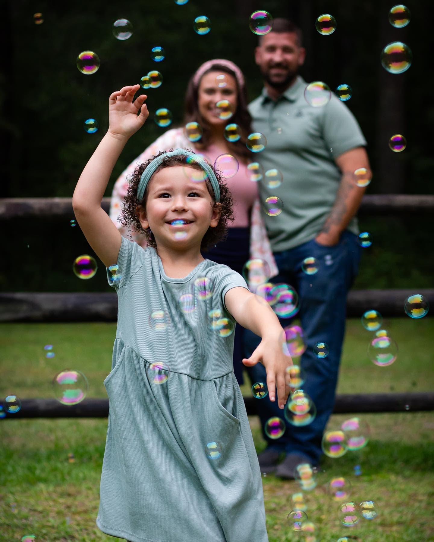 A family playing with bubbles in an open field